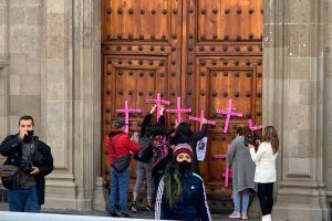 Mujeres saltan vallas y colocan cruces en puerta principal de Palacio Nacional